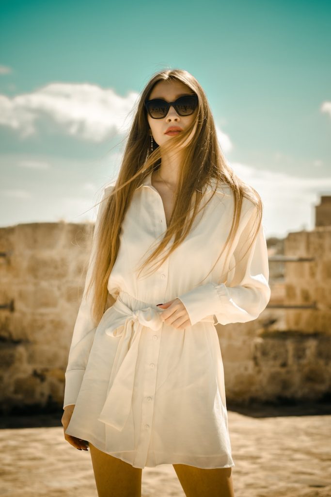 woman in white long sleeve business professional dress wearing black sunglasses